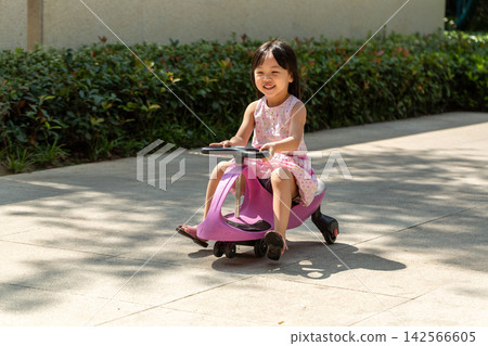 Cute Asian Little Girl Riding Wiggle Car Outdoors in Sunny Park Cute Asian Little Girl Riding Wiggle Car Outdoors in Sunny Park 142566605