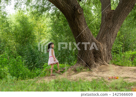 Asian Little Girl Walking Alone in Green Nature Park Under Tree Asian Little Girl Walking Alone in Green Nature Park Under Tree 142566609