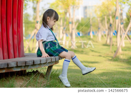 Cute Asian little girl sitting outdoors in park, smiling child enjoying nature and childhood moment Cute Asian little girl sitting outdoors in park, smiling child enjoying nature and childhood moment 142566675