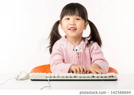 Happy Asian Little Girl Typing on Keyboard and Smiling Happy Asian Little Girl Typing on Keyboard and Smiling 142566684