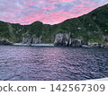 A sunset over a desert island, painted in lavender hues. 142567309