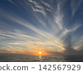 Clouds and sunsets compete against the blue sky. 142567929