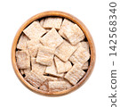 Cinnamon crunch squares, breakfast cereal in wooden bowl. Small, flat pieces made from whole wheat and rice flour, with ridges, to look like mini slices of toast. Eaten with milk or as a snack. Photo Cinnamon crunch squares, breakfast cereal in wooden bowl. Small, flat pieces made from whole wheat and rice flour, with ridges, to look like mini slices of toast. Eaten with milk or as a snack. Photo 142568340