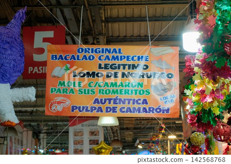 A sign advertising bacalao and shrimp ingredients displayed in a market in Mexico City. A sign advertising bacalao and shrimp ingredients displayed in a market in Mexico City. 142568768