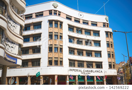 Imperial Casablanca hotel with art-deco facade and clock on bright blue sky in city center Imperial Casablanca hotel with art-deco facade and clock on bright blue sky in city center 142569222
