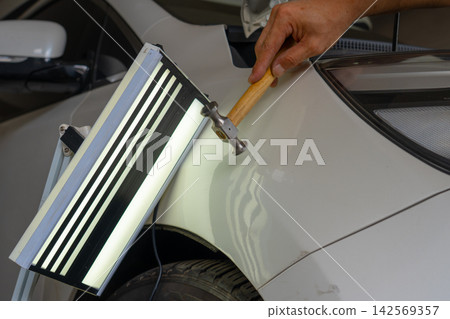 Removing dents on the car. PDR technology. Car body repair without painting. Removing dents on the car. PDR technology. Car body repair without painting. 142569357