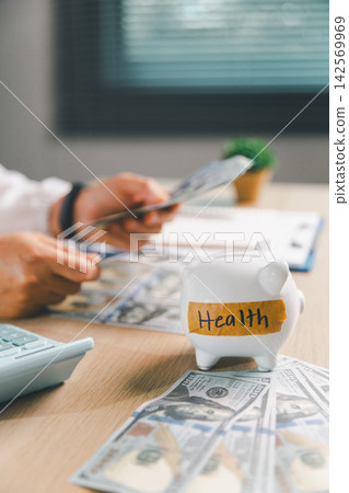 Healthcare professional counting dollar bills beside a calculator and piggy bank labeled Health, representing medical expenses, healthcare savings, budgeting, insurance costs, and financial planning. Healthcare professional counting dollar bills beside a calculator and piggy bank labeled Health, representing medical expenses, healthcare savings, budgeting, insurance costs, and financial planning. 142569969