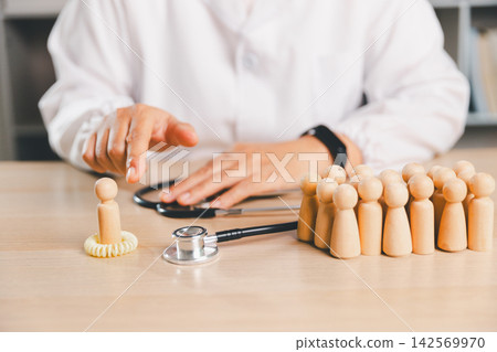 Healthcare professional placing a protective ring around a wooden person figure with a group behind, symbolizing patient protection, isolation, prevention, public health, safety, Healthcare professional placing a protective ring around a wooden person figure with a group behind, symbolizing patient protection, isolation, prevention, public health, safety, 142569970