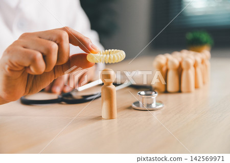 Healthcare professional placing a protective ring around a wooden person figure with a group behind, symbolizing patient protection, isolation, prevention, public health, safety, Healthcare professional placing a protective ring around a wooden person figure with a group behind, symbolizing patient protection, isolation, prevention, public health, safety, 142569971