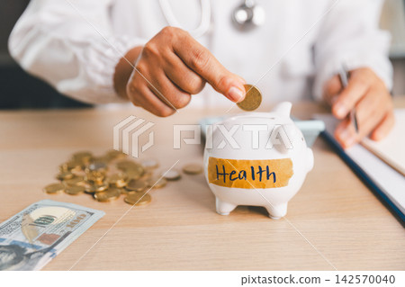 Healthcare professional placing a coin into a piggy bank labeled Health, representing medical savings, healthcare costs, insurance budgeting, financial protection, emergency funds, and future care. Healthcare professional placing a coin into a piggy bank labeled Health, representing medical savings, healthcare costs, insurance budgeting, financial protection, emergency funds, and future care. 142570040