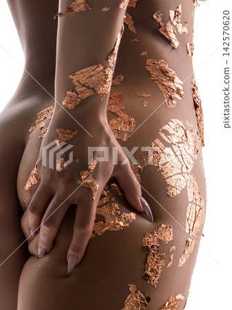 Body art featuring metallic leaf design on skin with elegant pose and soft lighting 142570620
