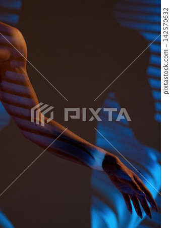 Artistic portrayal of an arm with shadows and light patterns in a creative setting Artistic portrayal of an arm with shadows and light patterns in a creative setting 142570632