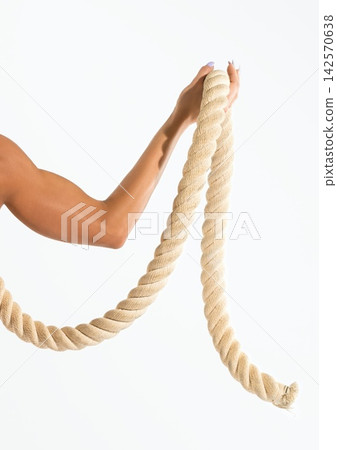 Person holding thick beige rope for workout on bright white background Person holding thick beige rope for workout on bright white background 142570638