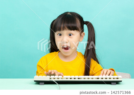 Shocked young girl looking at a computer monitor with wide eyes and open mouth at desk. Shocked young girl looking at a computer monitor with wide eyes and open mouth at desk. 142571366