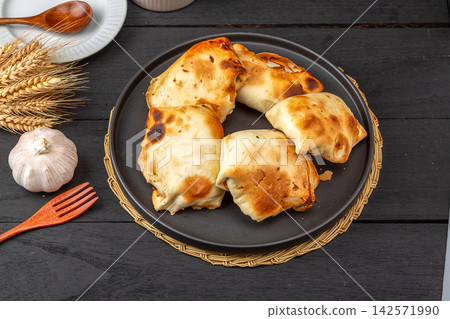 traditional Xinjiang Roasted Mutton Buns, Crispy Clay Oven Baked Samsa with Meat Filling traditional Xinjiang Roasted Mutton Buns, Crispy Clay Oven Baked Samsa with Meat Filling 142571990
