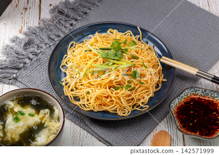 traditional Chinese cold noodles with scallion oil and shredded cucumber in a blue floral bowl traditional Chinese cold noodles with scallion oil and shredded cucumber in a blue floral bowl 142571999