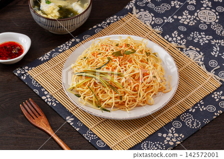 traditional Chinese cold noodles with scallion oil and shredded cucumber in a blue floral bowl traditional Chinese cold noodles with scallion oil and shredded cucumber in a blue floral bowl 142572001