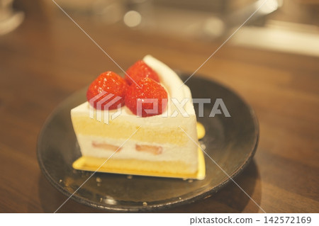 A cafe-style strawberry shortcake placed on a wooden table. A cafe-style strawberry shortcake placed on a wooden table. 142572169