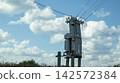 A transformer shed in a field on a sunny day. 142572384