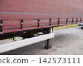 Semi-trailer truck parked near an industrial building 142573111