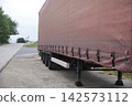 Semi-trailer truck parked near an industrial building 142573112