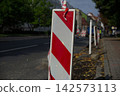 Road construction and traffic diversion with temporary traffic lights and roadworks barriers 142573113