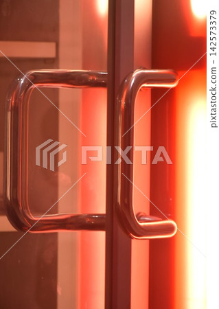 red light sift out from glass door with stainless handle ajar out in the dark red light sift out from glass door with stainless handle ajar out in the dark 142573379