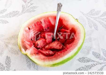 half fresh watermelon with tablespoon on table half fresh watermelon with tablespoon on table 142573530