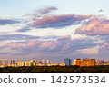 dark pink clouds in blue sunset sky over city 142573534