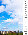 blue sky with large white cloud over city district 142573535