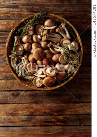 An assortment of mushrooms on a rustic wooden board with sprigs of thyme. An assortment of mushrooms on a rustic wooden board with sprigs of thyme. 142574291