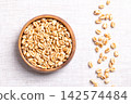 Honey wheats, puffed wheat with honey in a wooden bowl on linen. Sweetened, puffed breakfast cereal made from whole wheat kernels, coated in honey and sugar, enjoyed with milk, or as a snack. Photo Honey wheats, puffed wheat with honey in a wooden bowl on linen. Sweetened, puffed breakfast cereal made from whole wheat kernels, coated in honey and sugar, enjoyed with milk, or as a snack. Photo 142574484