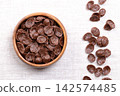 Choco chips, crispy breakfast cereal in a wooden bowl on linen. Crispy wheat food made of toasted wheat flour, cocoa powder, and sweetened with sugar. Enjoyed with milk, or eaten as a snack. Photo Choco chips, crispy breakfast cereal in a wooden bowl on linen. Crispy wheat food made of toasted wheat flour, cocoa powder, and sweetened with sugar. Enjoyed with milk, or eaten as a snack. Photo 142574485