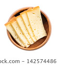 Slices of smoked semi-hard cheese, stacked in a wooden bowl. Cross-sections from Traunstein smoked cheese from Austria, with a creamy texture and a beechwood smoke flavor. Isolated, from above. Photo Slices of smoked semi-hard cheese, stacked in a wooden bowl. Cross-sections from Traunstein smoked cheese from Austria, with a creamy texture and a beechwood smoke flavor. Isolated, from above. Photo 142574486