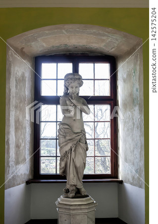 Statue of young girl holding rose in Nowy Wisnicz castle, Poland Statue of young girl holding rose in Nowy Wisnicz castle, Poland 142575204