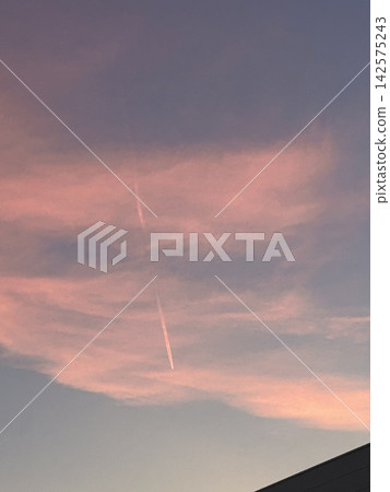 夕陽西下,天空被染成粉紅色,凝結尾跡和粉紅色的雲朵交相輝映。 夕陽西下,天空被染成粉紅色,凝結尾跡和粉紅色的雲朵交相輝映。 142575243