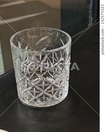 Empty Decorative Cut Glass Tumbler on Dark Restaurant Table Empty Decorative Cut Glass Tumbler on Dark Restaurant Table 142575323