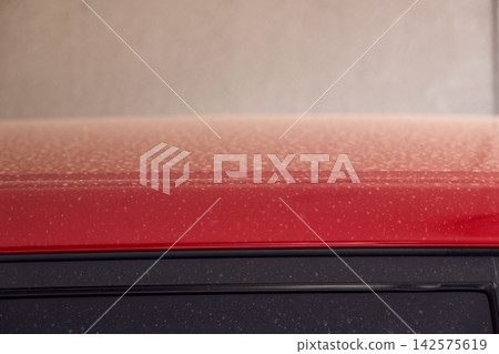 The body of a red car, dirty with yellow dust and pollen after the rain. The body of a red car, dirty with yellow dust and pollen after the rain. 142575619