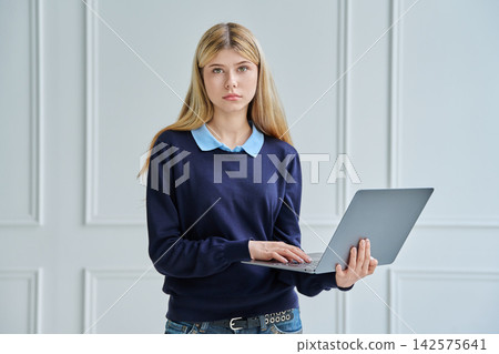 Portrait of teenage student girl holding a laptop Portrait of teenage student girl holding a laptop 142575641