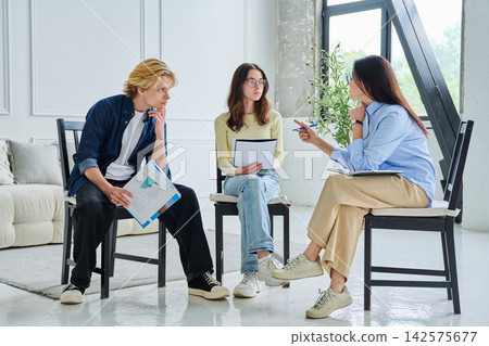 Social worker consulting two students in the office Social worker consulting two students in the office 142575677