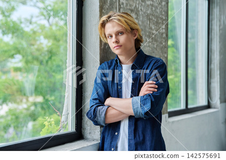 Handsome teenage boy with crossed arms looking at camera Handsome teenage boy with crossed arms looking at camera 142575691