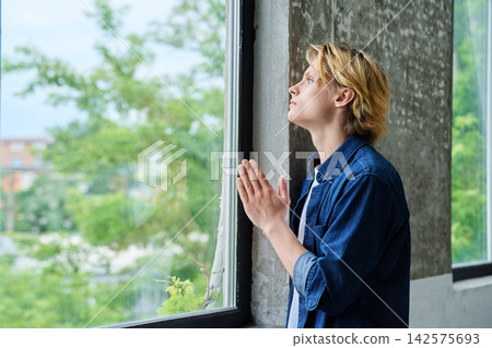 Peaceful teenage student praying with closed eyes Peaceful teenage student praying with closed eyes 142575693
