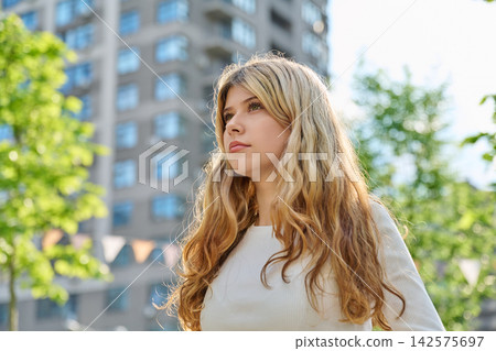 Pretty blonde teenage girl looking away in city Pretty blonde teenage girl looking away in city 142575697