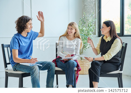 Teenage boy raising hand during group therapy session Teenage boy raising hand during group therapy session 142575712