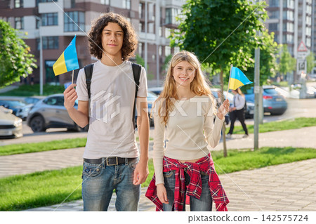 Happy Ukrainian teenagers holding small national flags Happy Ukrainian teenagers holding small national flags 142575724