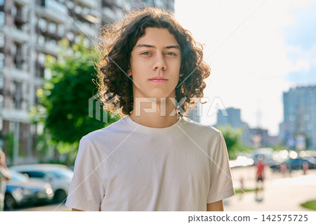 Portrait of confident teenage boy with curly hair outdoors Portrait of confident teenage boy with curly hair outdoors 142575725