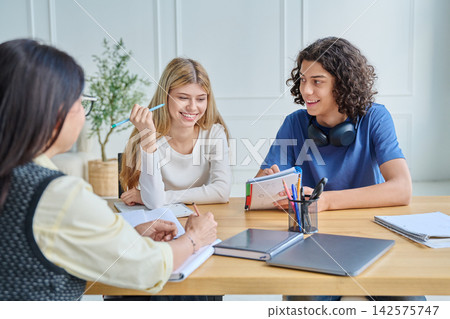 Happy teenage students working on project together Happy teenage students working on project together 142575747