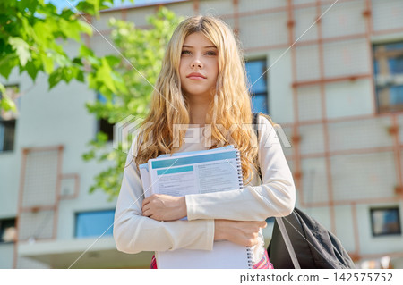 Teenage student girl in front of school building Teenage student girl in front of school building 142575752