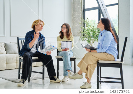 Young students talking to female counselor at office Young students talking to female counselor at office 142575761