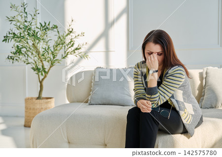 Mature sad woman experiencing stress, mental and physical pain, at home Mature sad woman experiencing stress, mental and physical pain, at home 142575780